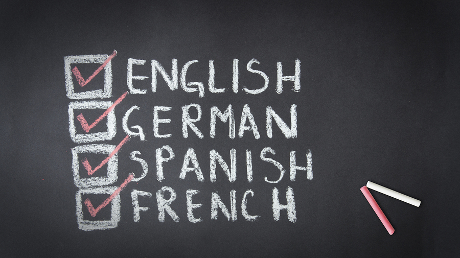 Language options on a chalkboard including English, German, Spanish and French.